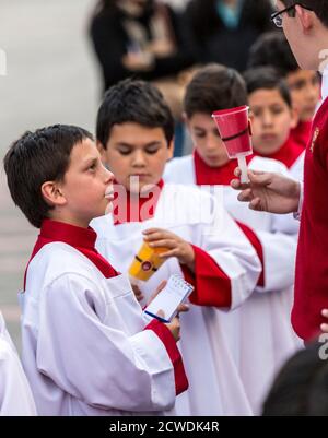 Cuenca, Ecuador - Giugno 4, 2015 - Vice parroco cattolico sacerdote partecipante parla ai giovani ragazzi prima di Corpus Cristi processione Foto Stock