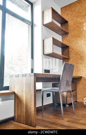 Arredamento moderno. Box joint scrivania console in legno massiccio con ripiani sullo sfondo della finestra Foto Stock