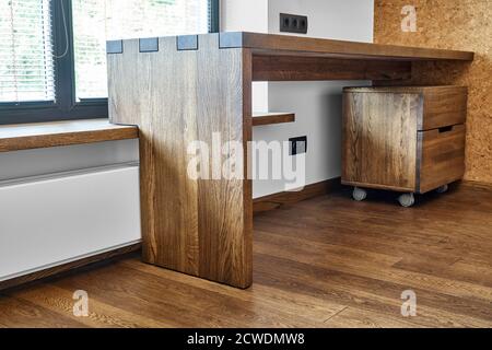 Arredamento moderno. Console in legno massello con giunzione a scatola sullo sfondo della finestra Foto Stock