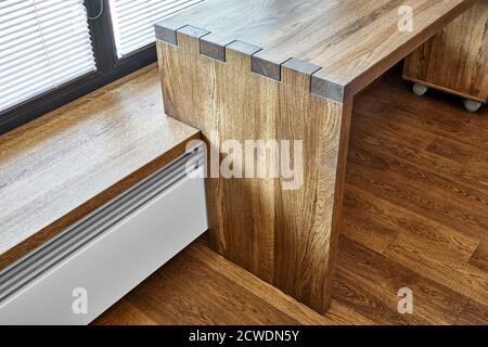 Arredamento moderno. Console in legno massello con giunzione a scatola sullo sfondo della finestra Foto Stock