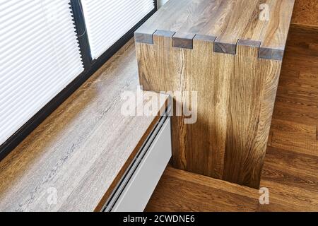 Arredamento moderno. Console in legno massello con giunzione a scatola sullo sfondo della finestra Foto Stock