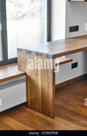 Arredamento moderno. Console in legno massello con giunzione a scatola sullo sfondo della finestra Foto Stock