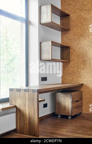 Arredamento moderno. Box joint scrivania console in legno massiccio con ripiani sullo sfondo della finestra Foto Stock