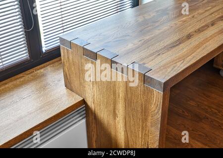 Arredamento moderno. Console in legno massello con giunzione a scatola sullo sfondo della finestra Foto Stock