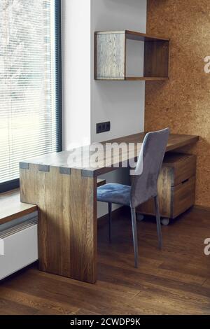 Arredamento moderno. Box joint scrivania console in legno massiccio con ripiani sullo sfondo della finestra Foto Stock