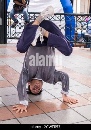 Cuenca, Ecuador - 13 agosto 2015 - ragazzo adolescente practice break dance stand di testa nel parco Foto Stock