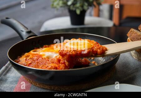 Shakshouka - uova in salsa di pomodoro, servite in padella Foto Stock