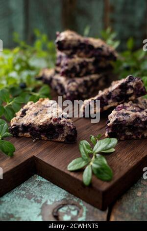 Focaccine di mirtillo su tavola di quercia con foglie di bacche verticali Foto Stock