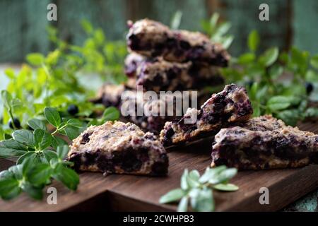 Focaccine di mirtillo su tavola di quercia con closeup foglie di mirtillo Foto Stock