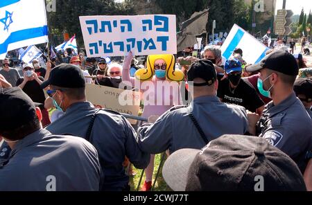 GERUSALEMME, ISRAELE - 29 SETTEMBRE: Un manifestante vestito da un busty costume cartoon tiene un cartello che recita "la democrazia era qui" di fronte al parlamento israeliano durante una manifestazione sulla legislazione che limita le proteste in un blocco a livello nazionale volto a contenere la pandemia del coronavirus il 29 settembre 2020 a Gerusalemme, Israele. Il parlamento israeliano ha approvato modifiche alla legge del Coronavirus che limiterebbero le proteste contro il primo ministro Benjamin Netanyahu chiedendo le sue dimissioni per la sua accusa di corruzione e la gestione della pandemia del coronavirus. Foto Stock