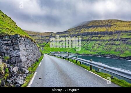 Strada iconica per il villaggio perduto nelle Isole Faroe Foto Stock