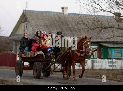 Performers ride on a horse-drawn cart as they sing Christmas carols, locally known as 'Kolyadki', in the village of Gantsevichi, about 180 km (112 miles) southeast of Minsk, January 13, 2012. Many Orthodox Belarussians mark New Year according to the Julian calendar on January 13.  REUTERS/Vasily Fedosenko(BELARUS - Tags: SOCIETY ANIMALS)