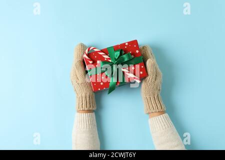 Mani femminili in mittens su sfondo blu Foto Stock