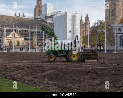 Paesaggisti visto al lavoro con macchinari pesanti e la posa di un nuovo prato sul giardino di Parliament Square. Foto Stock