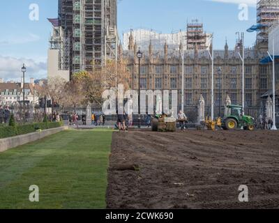 Paesaggisti visto al lavoro con macchinari pesanti e la posa di un nuovo prato sul giardino di Parliament Square. Foto Stock