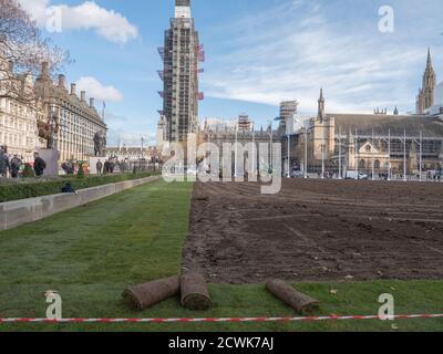 Paesaggisti visto al lavoro con macchinari pesanti e la posa di un nuovo prato sul giardino di Parliament Square. Foto Stock