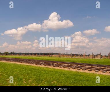 Oświęcim, Polonia - 05 Giugno 2019: i binari ferroviari e recinto elettrico in Auschwitz Birkenau Campo di concentramento. Sterminio ebraico camp. Europa Foto Stock