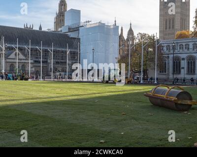 Paesaggisti visto al lavoro con macchinari pesanti e la posa di un nuovo prato sul giardino di Parliament Square. Foto Stock