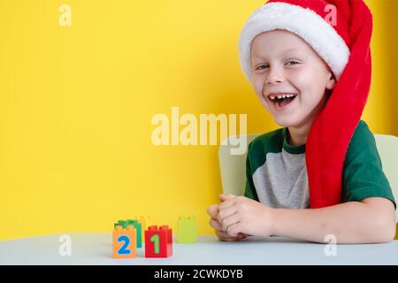 Il bambino in cappello di Santa sorridendo felice e giocando con blocchi colorati con numeri Foto Stock