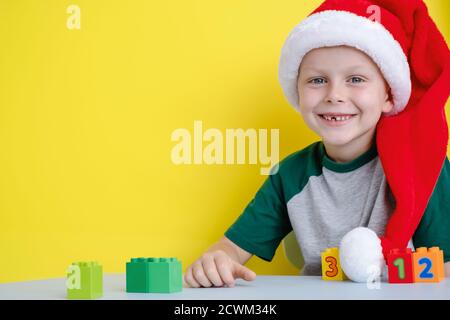 Il bambino in cappello di Santa sorridendo felice e giocando con blocchi colorati con numeri Foto Stock