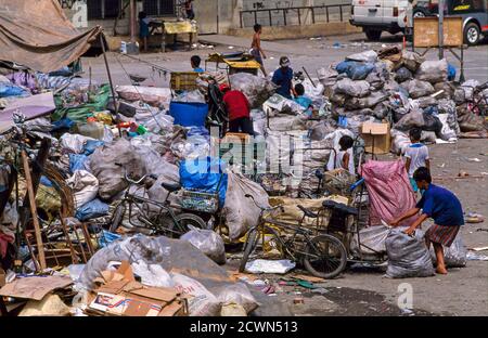 Le persone povere che scaraventano in un deposito di rifiuti riciclati, Manila, Filippine Foto Stock