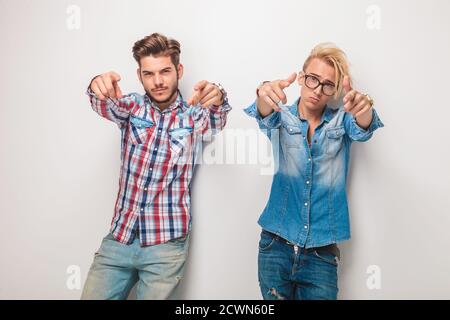 un paio di uomini casual di moda che vi scelgono puntando alla macchina fotografica, in studio Foto Stock