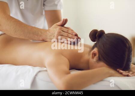 Cliente femminile ottenere rilassante massaggio medico professionale nel benessere moderno centro Foto Stock