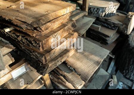 Aria-asciugando segato palo di lastra di legno di tavola sotto baldacchino a casa cortile preparato per carpenteria fai da te hobby. Negozio di legno nel cortile della casa. Materiale in legno Foto Stock