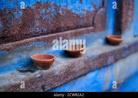 Lampada olio Pooja Diya lampada sulla parete blu della casa a Jodhpur, Rajasthan, India Foto Stock