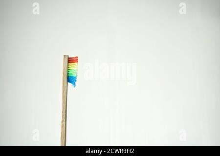 Profilo di uno spazzolino di bambù singolo usato con setole arcobaleno Foto Stock