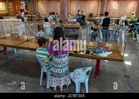 NONTHABURI, THAILANDIA, 20 2020 GIUGNO, l'interno del tempio buddista con tavoli adattati per la distanza sociale in durata coronavirus pandemia. WA Foto Stock