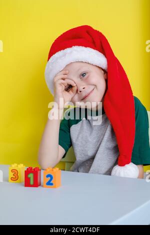 Il bambino in cappello di Santa sorridendo felice e giocando con blocchi colorati con numeri Foto Stock