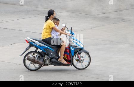 SAMUT PRAKAN, THAILANDIA, 03 2020 LUGLIO, la donna corre su una motocicletta con uno scolaro in uniforme. Foto Stock