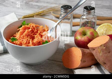 insalata fresca di verdure crude in una ciotola di patate dolci raspate con mele Foto Stock