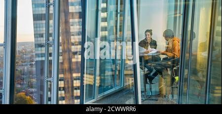 Gli uomini d'affari si riunano alla finestra dell'ufficio Foto Stock