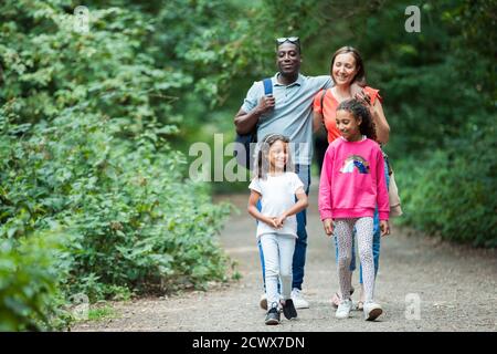 Felice famiglia escursioni in pista in boschi Foto Stock