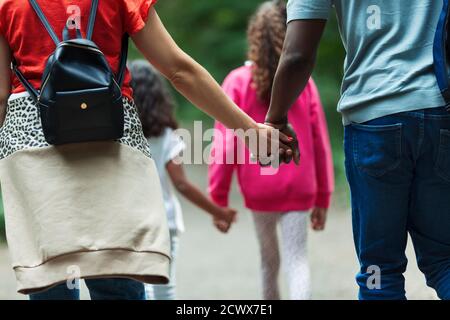 Famiglia affettuosa che tiene le mani e cammina sul sentiero Foto Stock