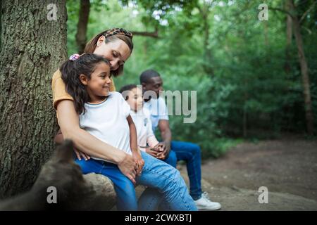 Famiglia felice riposarsi in escursione in boschi Foto Stock