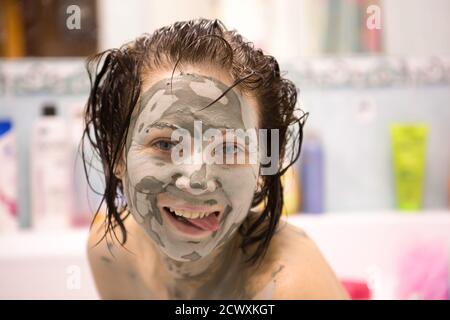 Bella ragazza con fango sul viso. Maschera cosmetica. Viso di bellezza. Foto Stock