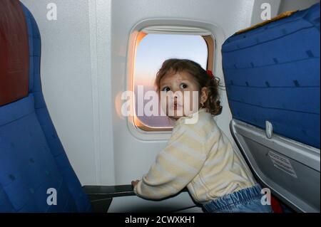 un bambino guarda fuori la finestra su un aereo Foto Stock