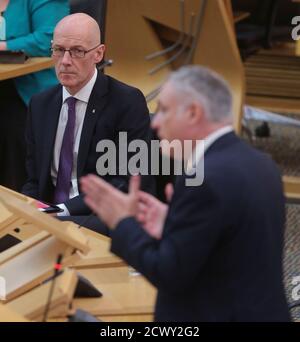 Il Vice primo Ministro John Swinney (a sinistra) e il Ministro per l'Istruzione superiore, l'Istruzione superiore e la Scienza Richard Lochhead durante le interrogazioni d'attualità al Parlamento scozzese a Holyrood, Edimburgo. Foto Stock