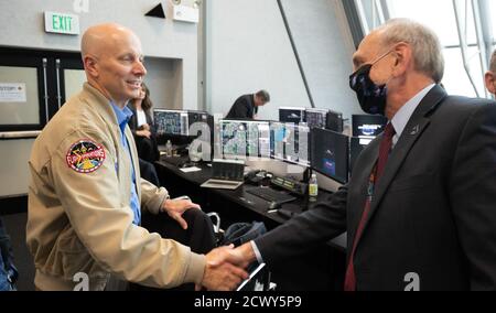 Lancio di SpaceX Demo-2 Stephen Koerner, Direttore della direzione operativa del volo presso il Johnson Space Center della NASA, Shakes mani con l'amministratore associato della NASA Steve Jurczyk dopo il lancio di un razzo SpaceX Falcon 9 che trasporta la navicella spaziale Crew Dragon dell'azienda nella missione Demo-2 con gli astronauti della NASA Douglas Hurley e Robert Behnken a bordo, sabato 30 maggio 2020, Nella stanza di sparo quattro del Launch Control Center presso il Kennedy Space Center della NASA in Florida. La missione SpaceX Demo-2 della NASA è il primo lancio con gli astronauti della navicella spaziale SpaceX Crew Dragon e del razzo Falcon 9 Foto Stock