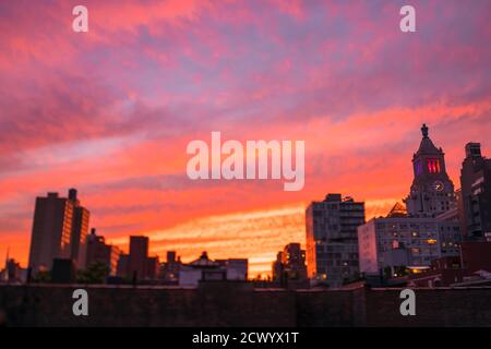 Il cielo si illumina in viola al tramonto a East Village New York City. Foto Stock