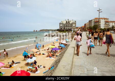 Hendaye, Paesi Baschi francesi, Francia - 13 luglio 2019 : la gente cammina nella passeggiata e rilassarsi in spiaggia con il vecchio Casino in stile neo-moresco b Foto Stock