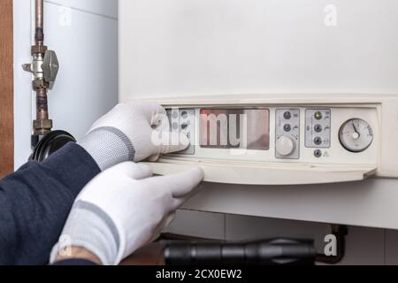 Tecnico che effettua la manutenzione della caldaia di riscaldamento in una casa. Concetto di manutenzione Foto Stock