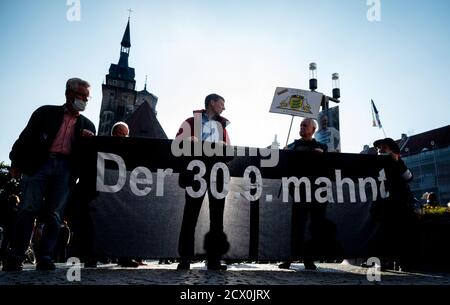 Stoccarda, Germania. 30 settembre 2020. I partecipanti di una marcia silenziosa hanno in mano un banner con l'iscrizione 'il 30.09. Avverte'. Con una marcia silenziosa, gli oppositori del progetto ferroviario di Stoccarda 21 hanno ricordato agli uomini gli scontri del cosiddetto 'giovedì nero'. Durante l'operazione di polizia del 30 settembre 2010, il conflitto sul progetto ferroviario multimiliardi di euro di Stoccarda del 21 si era intensificato. Più di 100 persone sono state ferite nello Schlossgarten, principalmente per l'uso di cannoni ad acqua. Il giorno è andato giù nella storia dello stato come 'il giovedì nero'. Credit: Marijan Murat/dpa/Alamy Live News Foto Stock