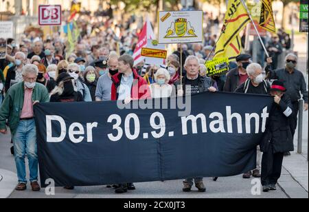 Stoccarda, Germania. 30 settembre 2020. I partecipanti di una marcia silenziosa hanno in mano un banner con l'iscrizione 'il 30.09. Avverte'. Con una marcia silenziosa, gli oppositori del progetto ferroviario di Stoccarda 21 hanno ricordato agli uomini gli scontri del cosiddetto 'giovedì nero'. Durante l'operazione di polizia del 30 settembre 2010, il conflitto sul progetto ferroviario multimiliardi di euro di Stoccarda del 21 si era intensificato. Più di 100 persone sono state ferite nello Schlossgarten, principalmente per l'uso di cannoni ad acqua. Il giorno è andato giù nella storia dello stato come 'il giovedì nero'. Credit: Marijan Murat/dpa/Alamy Live News Foto Stock