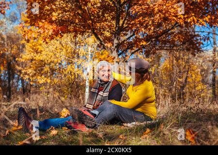 Passeggiata nella stagione autunnale. Coppia senior seduto nel parco. Uomo felice e donna rilassarsi all'aperto divertendosi godendo la natura Foto Stock