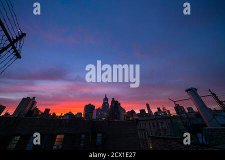 Il cielo si illumina in viola al tramonto a East Village New York City. Foto Stock