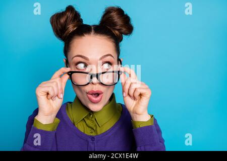 Closeup foto di attraente signora due buns divertente buon umore take off vision eyesight specs interested look side spazio vuoto indossare il colletto viola della camicia Foto Stock